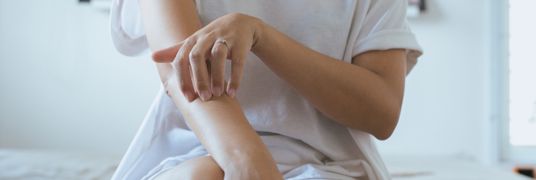 person scratching their arm because of psoriasis