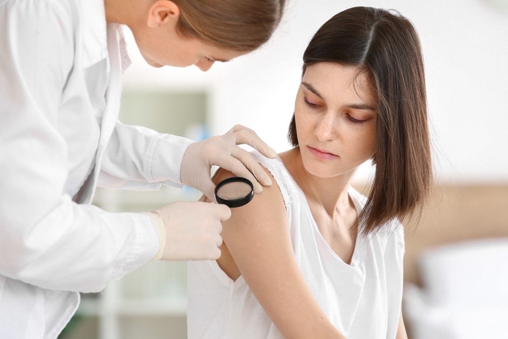 Woman having her skin examined by a dermatologist for early detection of skin cancer.