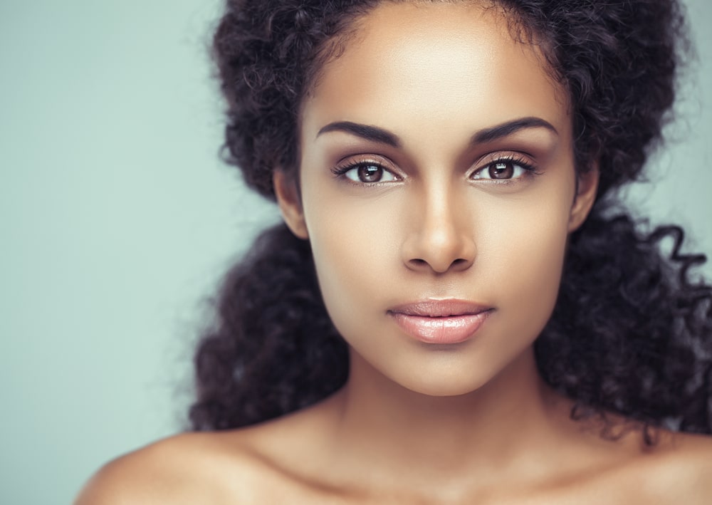 Woman examining skin for possible signs of skin cancer in Plantation, FL